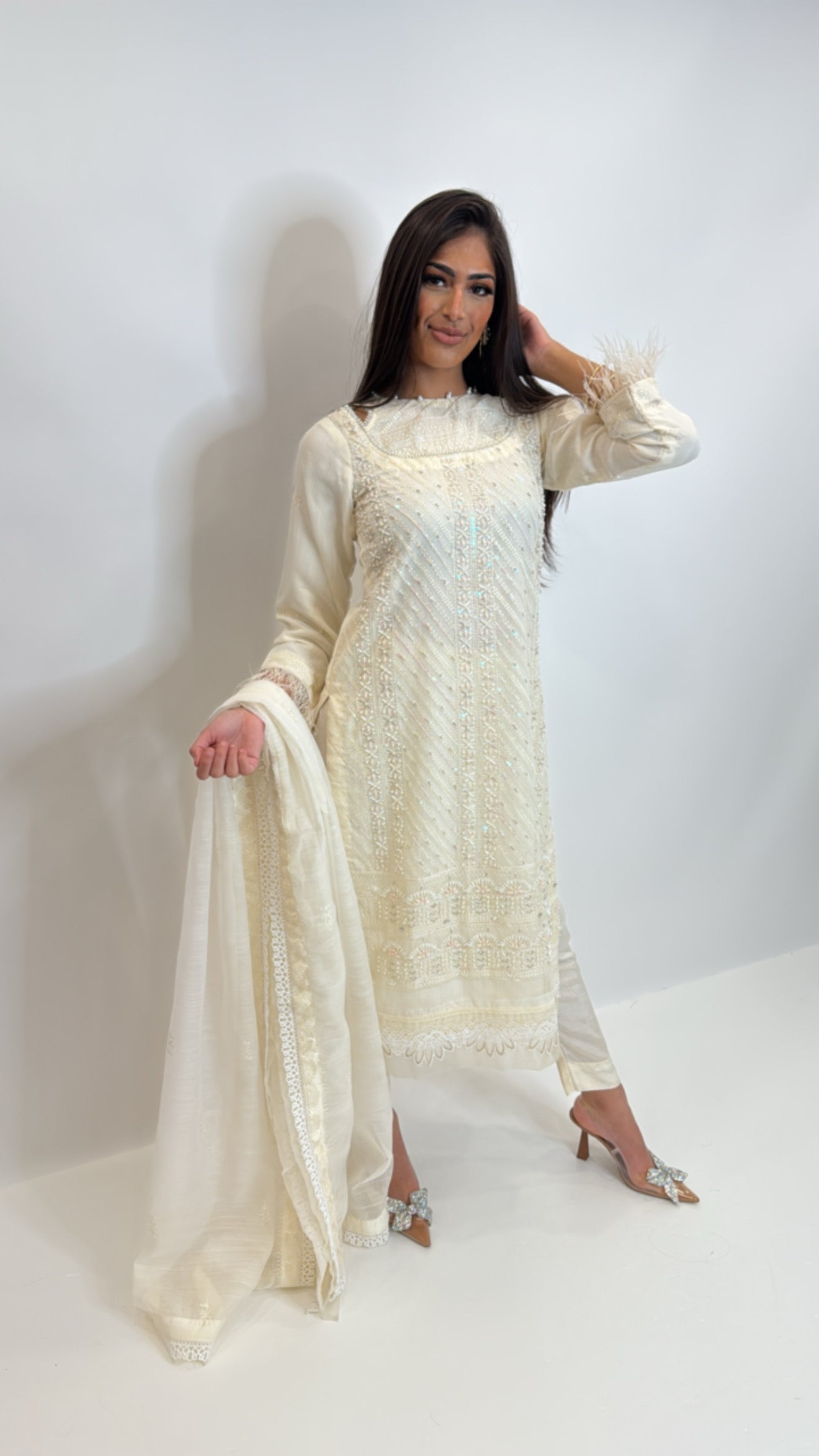 Close up of feather detailing on sleeve cuffs of khaki net kameez.