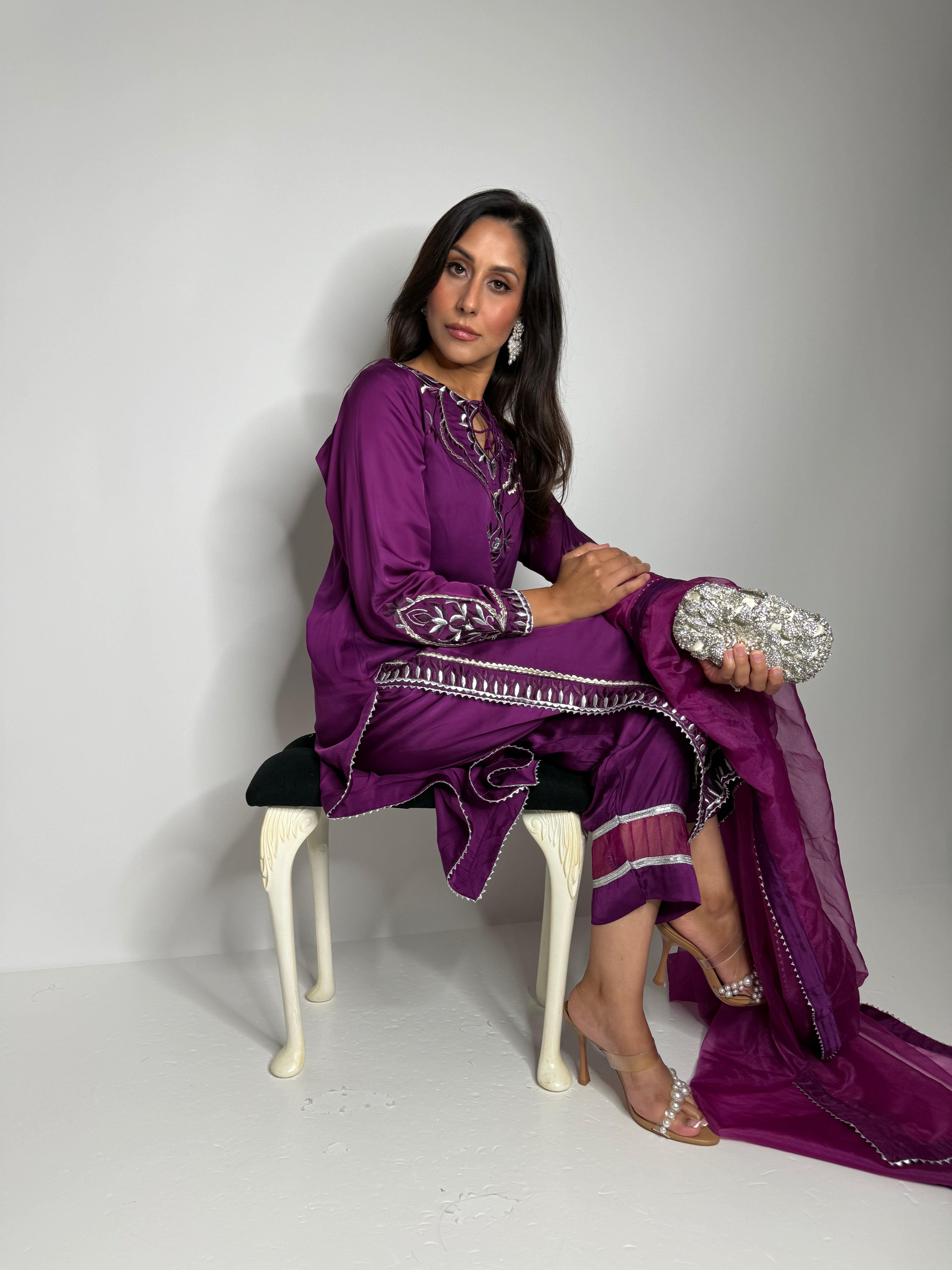 Embroidered hem detail on plum silk shirt